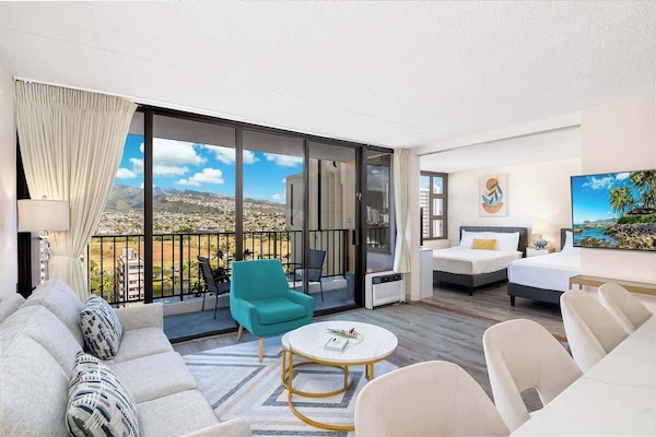 Relax and enjoy this beautiful condo with a mountain view, a pull-out sleeper sofa, a coffee table, a chair, and a flat-screen TV.