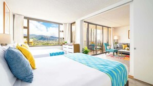 Una camera d'albergo con un letto grande, una scrivania, una sedia e un balcone con vista sulla città.