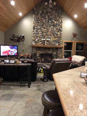 Cozy space with a vaulted ceiling, stone fireplace, and comfortable seating areas.