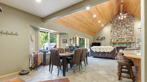 A spacious dining area with a high ceiling and stone walls.