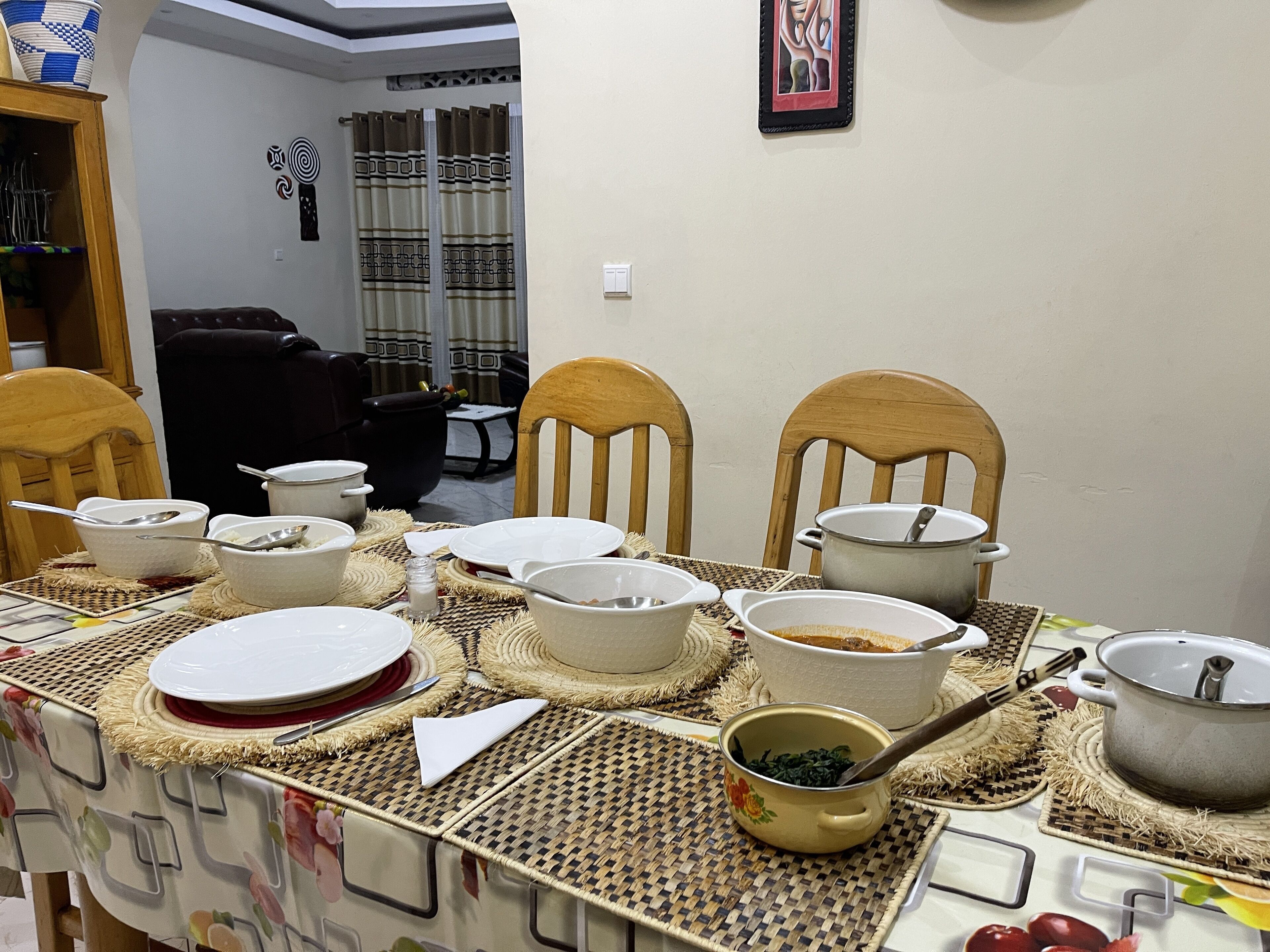 Una mesa de comedor dispuesta con diferentes platos y cubiertos, rodeada de sillas.