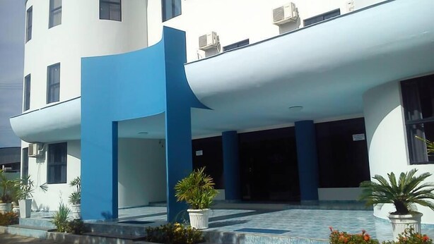 A modern building with a curved facade, multiple windows, and air conditioning units. - Hotel Jacarandá (Teixeira de Freitas)
