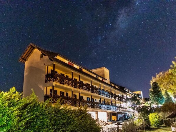 A multi-story hotel with balconies, under a starry night sky. - Pousada dos Plátanos (Nova Petropolis)
