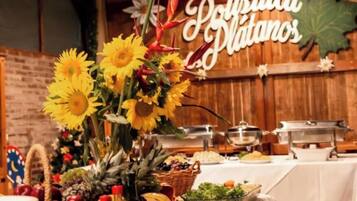 Uma mesa de buffet com diversos tipos de comida e um arranjo decorativo de girassóis.