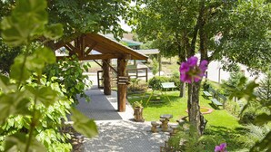 A covered outdoor area with a reception desk, seating, and a pool. - Pousada dos Plátanos (Nova Petropolis)