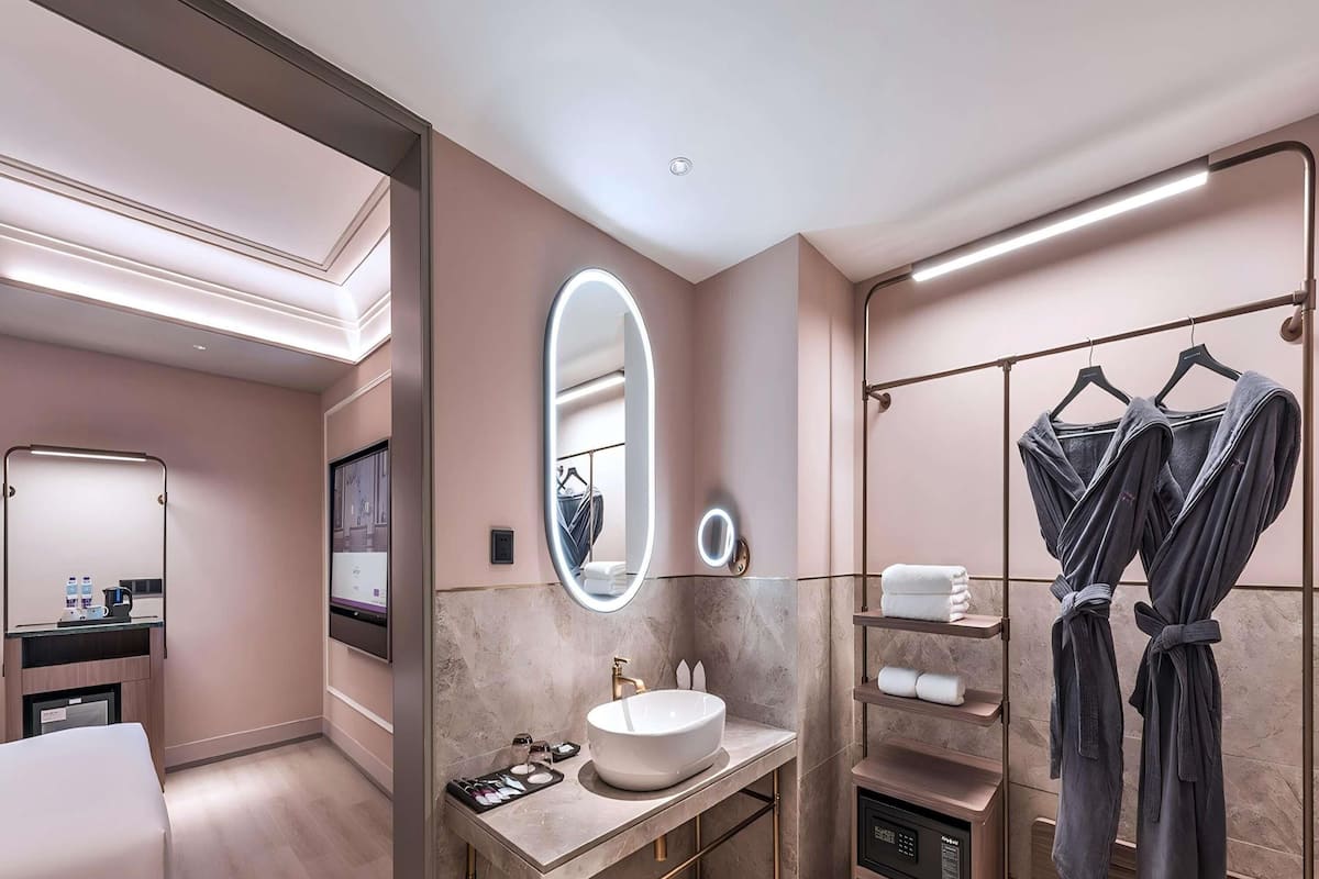 Un baño moderno con un espejo grande, un lavabo y un perchero para toallas.