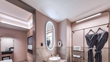 Un baño moderno con un espejo grande, un lavabo y un perchero para toallas.