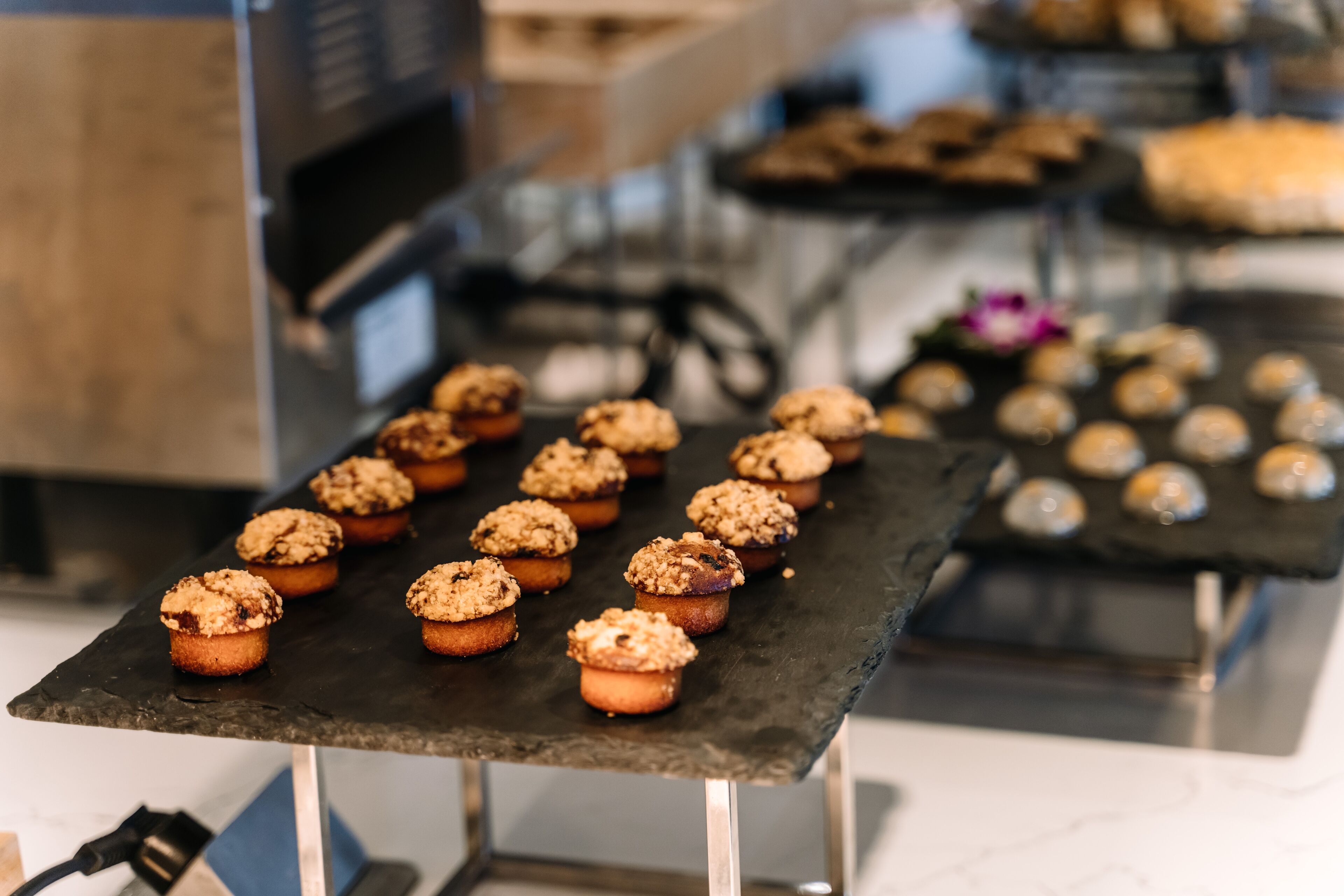 A kitchen counter with several muffins on it.