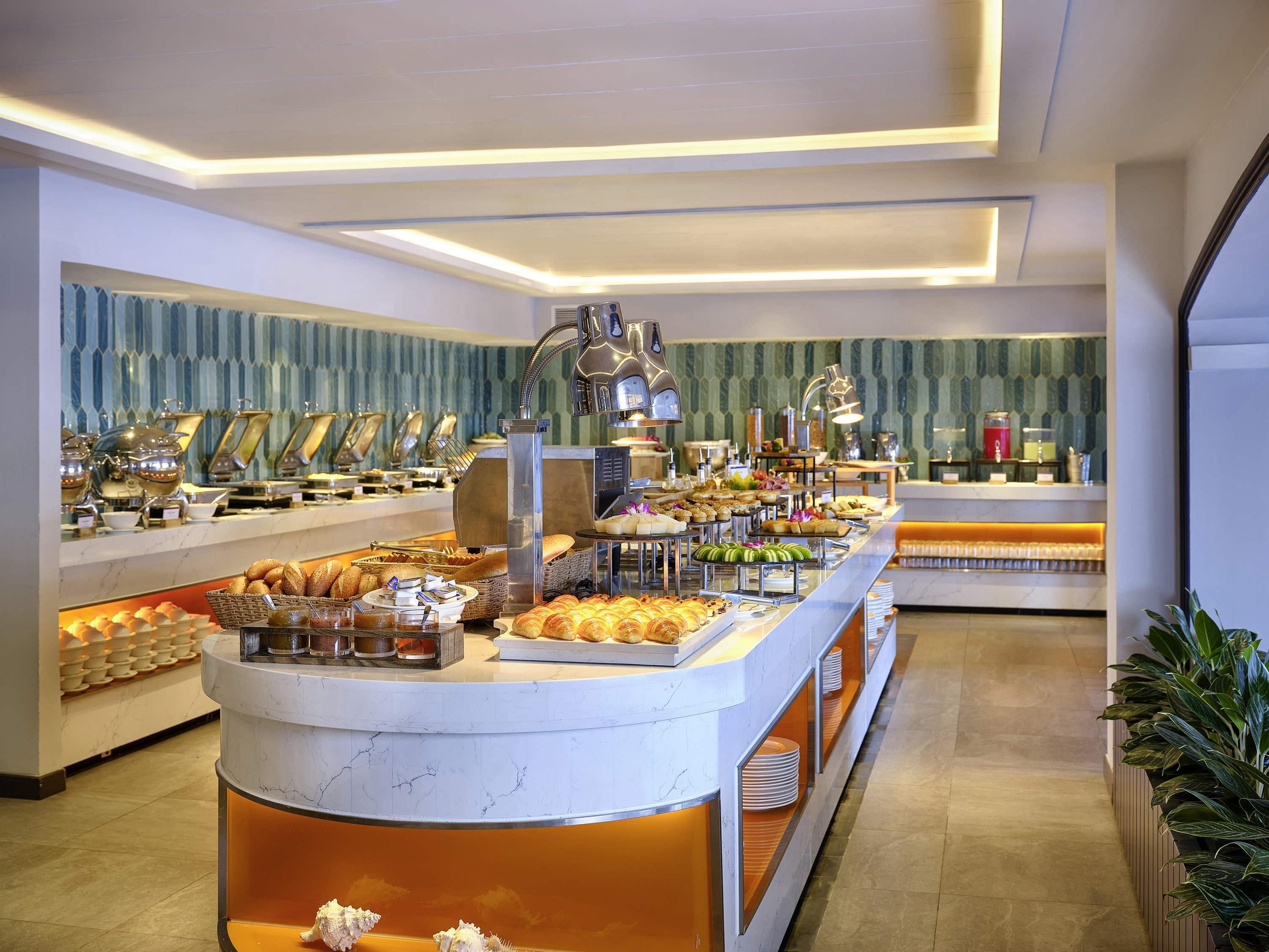 Un buffet proposant une variété de plats, un comptoir en marbre et un mur orné de motifs.