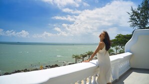 A balcony with a view of the sea and palm trees. - Mercure Vung Tau (Ho Chi Minh City)