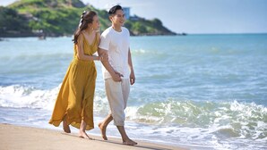 A couple walking on a beach with waves in the background. - Mercure Vung Tau (Ho Chi Minh City)