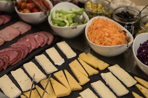 Artisanal cheeses and cured meats are arranged on a table for a culinary experience.