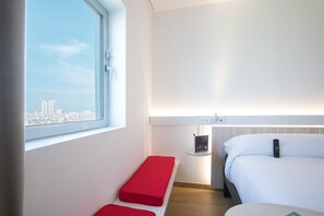Enjoy a city view from the large window, with a single bed and functional space for reading or working.