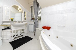 Bathtub, hair dryer, towels, toilet paper