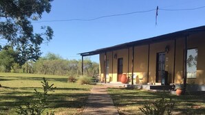 Un edificio con un camino que lleva a la entrada, rodeado de césped y árboles.