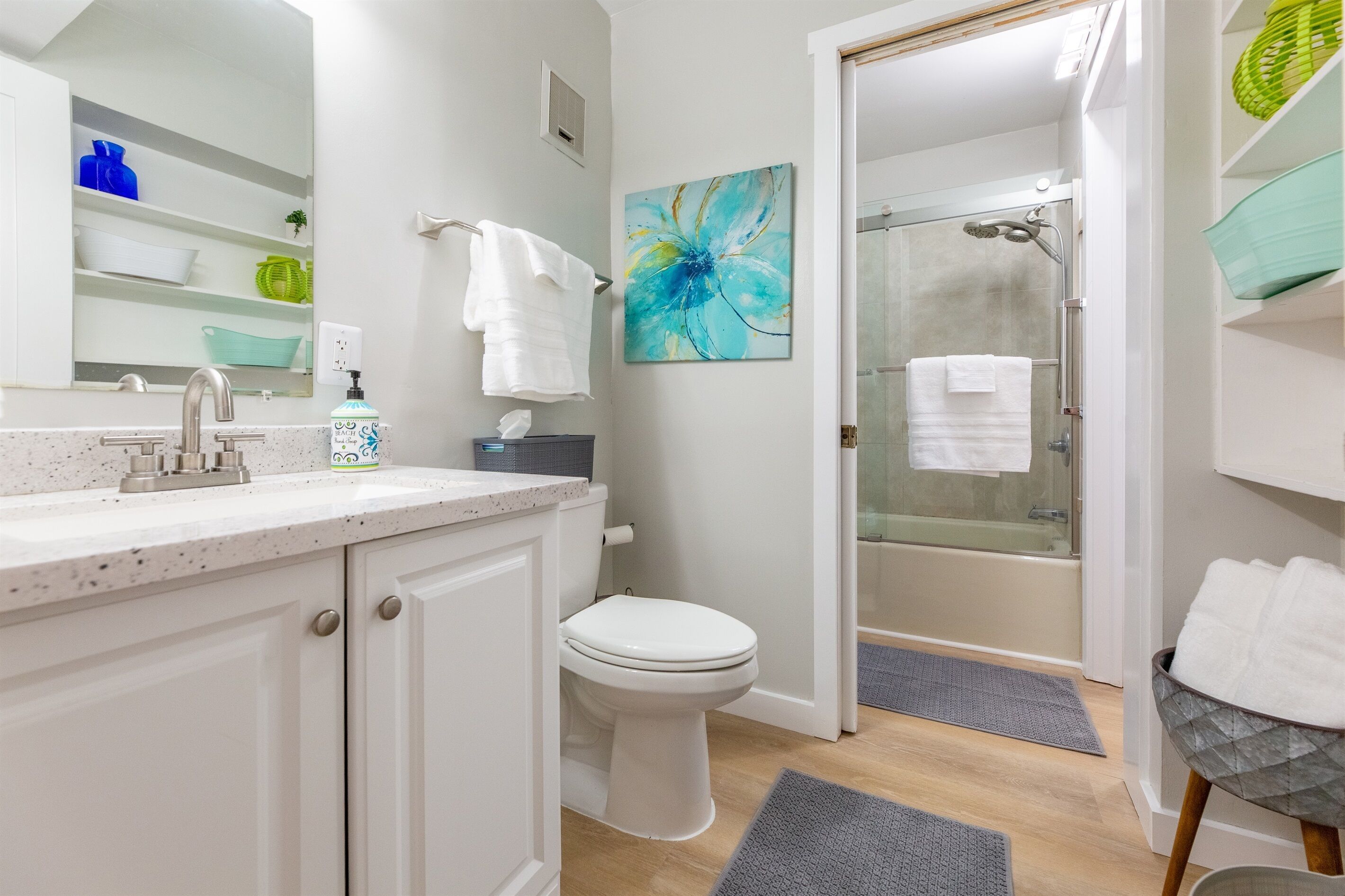 Un baño moderno con inodoro, lavamanos y zona de ducha.