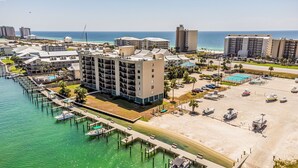 A coastal hotel with multiple floors, a marina with boats, and a beach area. - Orange Beach Gulf-Front 2BR • Sleeps 7 • 2 La-Z-Boy Recliners • Pools • Boats (Orange Beach)