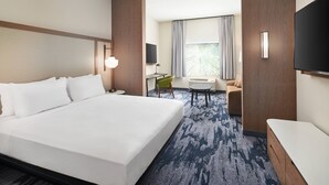 A hotel room with a large bed, a desk, a chair, a TV, and a window with curtains. - Fairfield Inn & Suites by Marriott Tampa Riverview (Riverview)