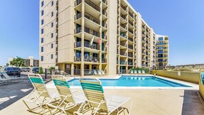 A hotel with a rooftop pool, multiple balconies, and lounge chairs. - Orange Beach Gulf View 2BR • Sleeps 6 • 2 Pools • Beach • Boat Slips (Orange Beach)