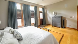 A bedroom with a bed, a dresser, a radiator, and a window with curtains. - Second Street Stay–Downtown+ WALKABLE TO CHERRY FEST (Traverse City)