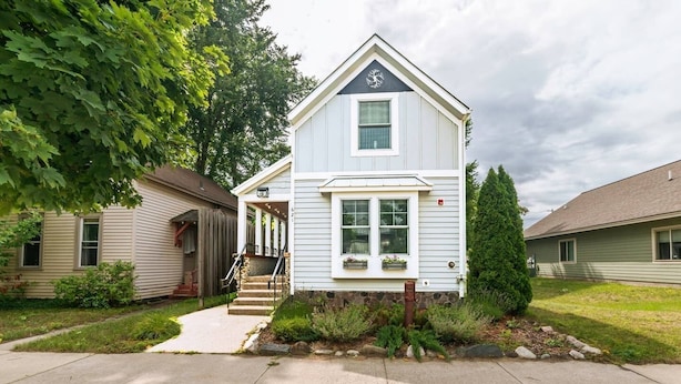 A single-story house with a front porch, a small front yard, and a driveway. - Second Street Stay–Downtown+ WALKABLE TO CHERRY FEST (Traverse City)