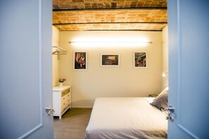 Una camera da letto con un letto, una cassettiera e tre quadri appesi al muro.