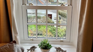 A bay window with a view of the sea and a garden below. - Little Gwyn. 3 min walk to Beach! Gorgeous views out to sea. (Gorran Haven)