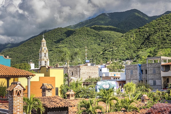 A town with a prominent church, a bell tower, and a mountain backdrop.