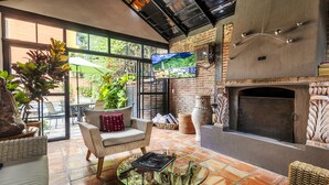 Un salon chaleureux avec une cheminée, des fauteuils confortables et un téléviseur.