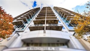 A high-rise building with a modern architectural design, featuring multiple balconies and a prominent entrance. - Prime Downtown Atlanta Condo with Luxury Amenities (Atlanta)