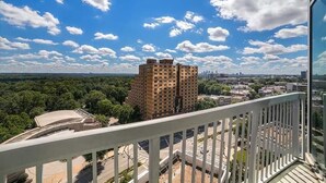 A high-rise building with a view of a cityscape and greenery. - Prime Downtown Atlanta Condo with Luxury Amenities (Atlanta)