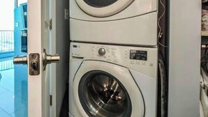 A stacked washer and dryer unit in a laundry room. - Prime Downtown Atlanta Condo with Luxury Amenities (Atlanta)