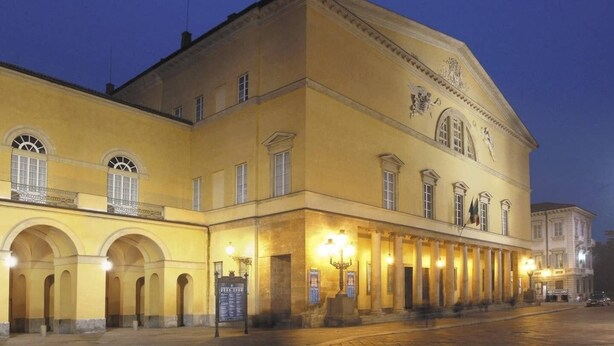 A historic building with a yellow facade, multiple arches, and classical columns. - Navel of Parma (Parma)