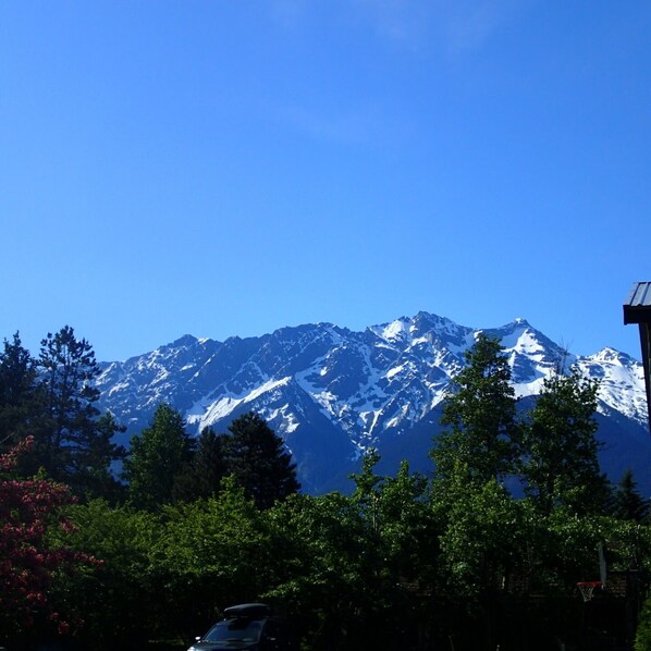 A mountain range with snow-capped peaks under a clear blue sky.