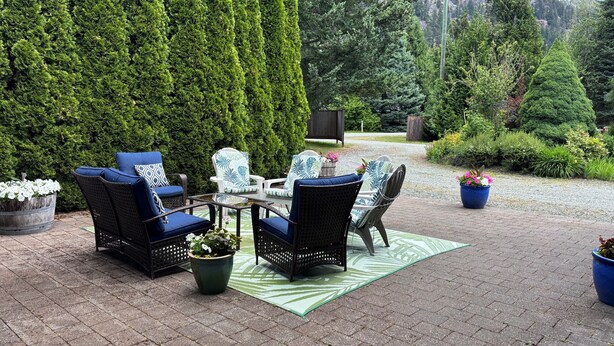 A patio with outdoor furniture, a table, and potted plants. - Spacious 2 bedroom suite on private lot (Pemberton)
