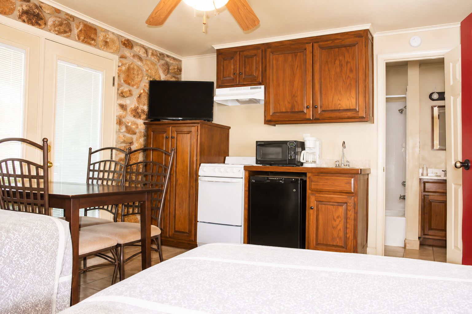 A compact kitchen with wooden cabinets, a microwave, a coffee maker, and a dishwasher.