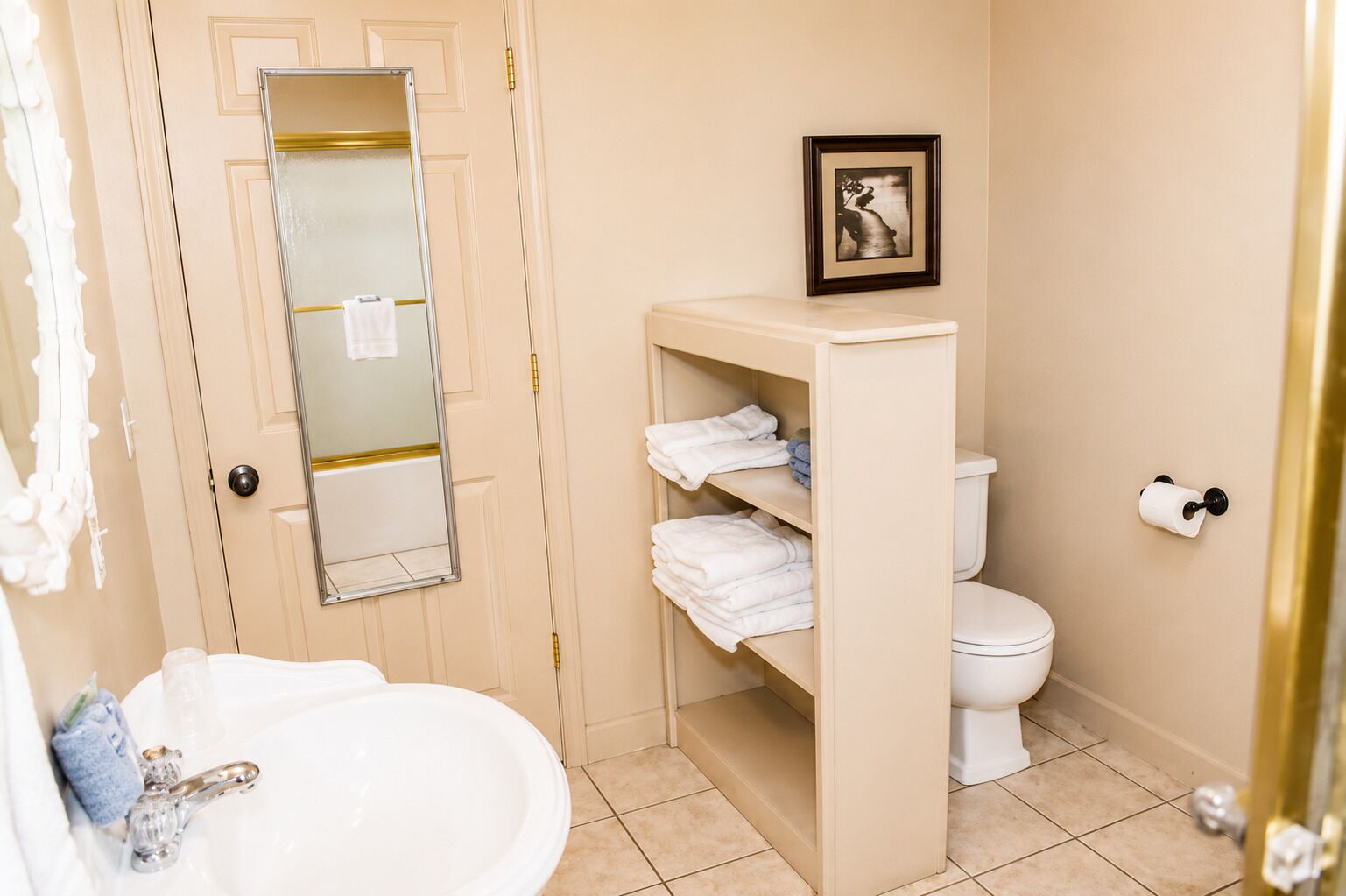 A bathroom with a sink, mirror, toilet, and towel rack.