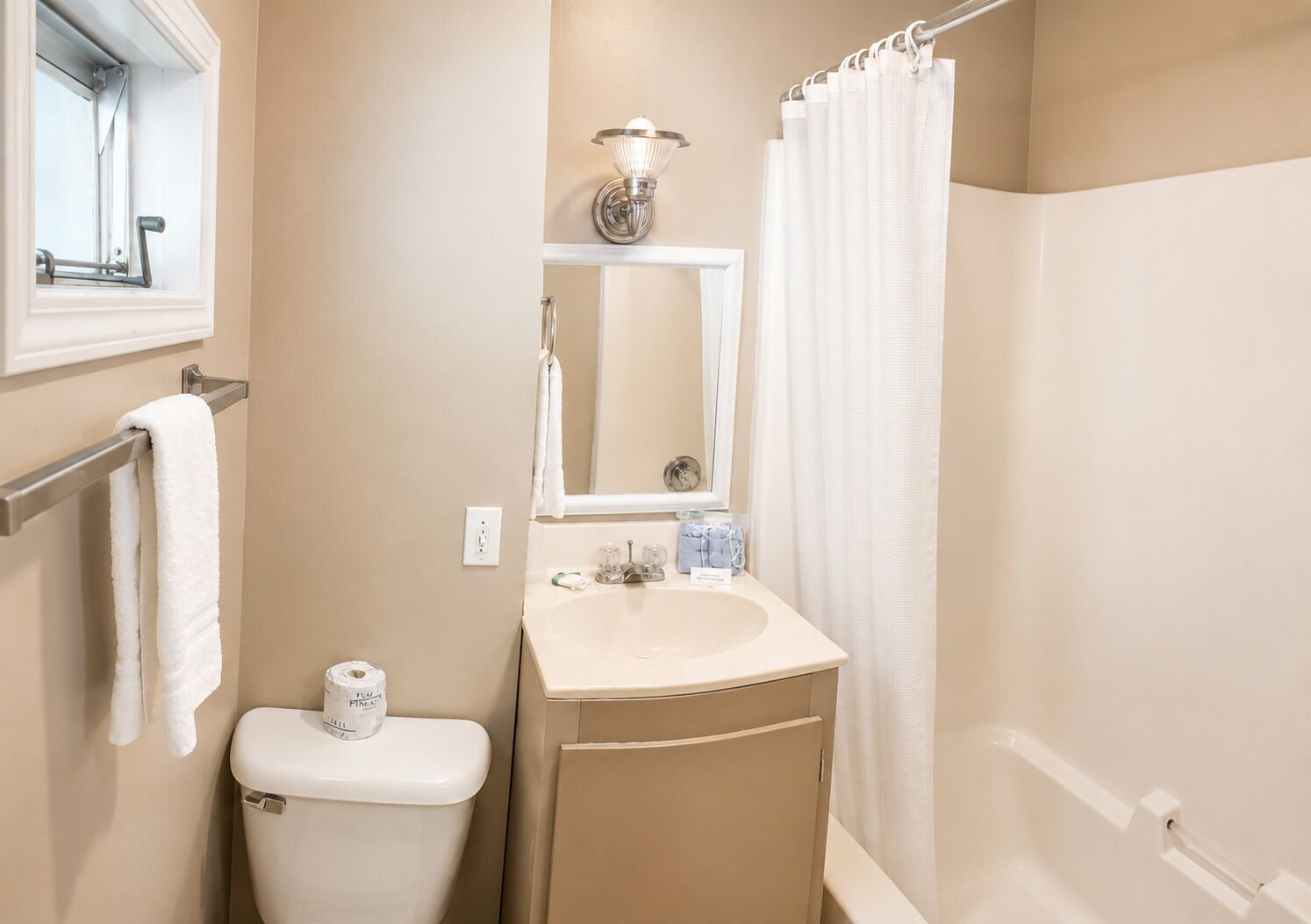 Ein Badezimmer mit Toilette, Waschbecken, Spiegel und Duschvorhang.
