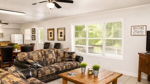 A living room with a patterned sofa, a wooden coffee table, and a television on a wooden cabinet. - Jack's White River Fishing Resort (Mountain View)