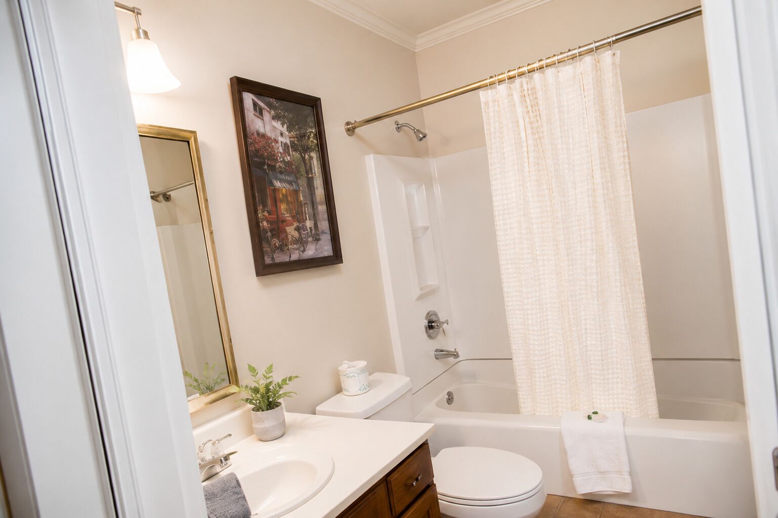 Une salle de bain équipée d’une baignoire, de toilettes, d’un lavabo et d’un rideau de douche.