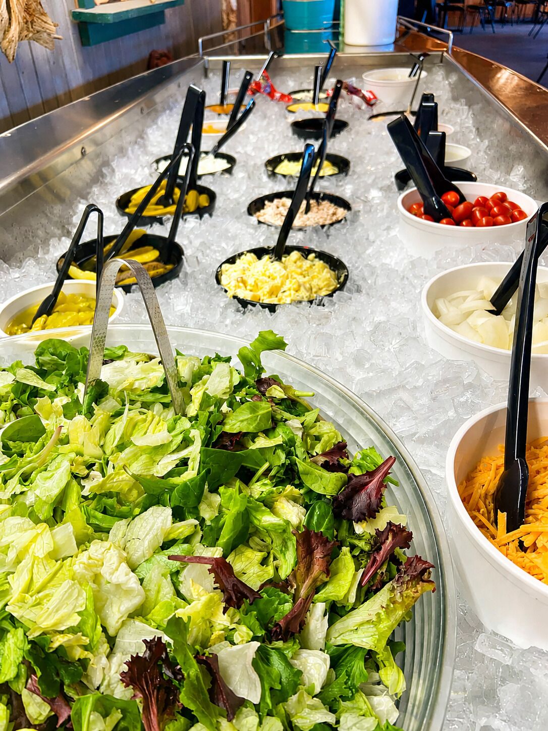 A buffet with various food options on ice, including salads, cheese, and other dishes.