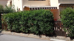 Ein zweistöckiges Gebäude mit einer beige farbenen Fassade, großen Fenstern und einem überdachten Eingang.