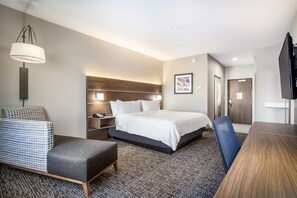 A modern hotel room with a bed, bedside table, chair, desk, and a television. - Holiday Inn Express & Suites Tulsa East - Catoosa by IHG (Tulsa)