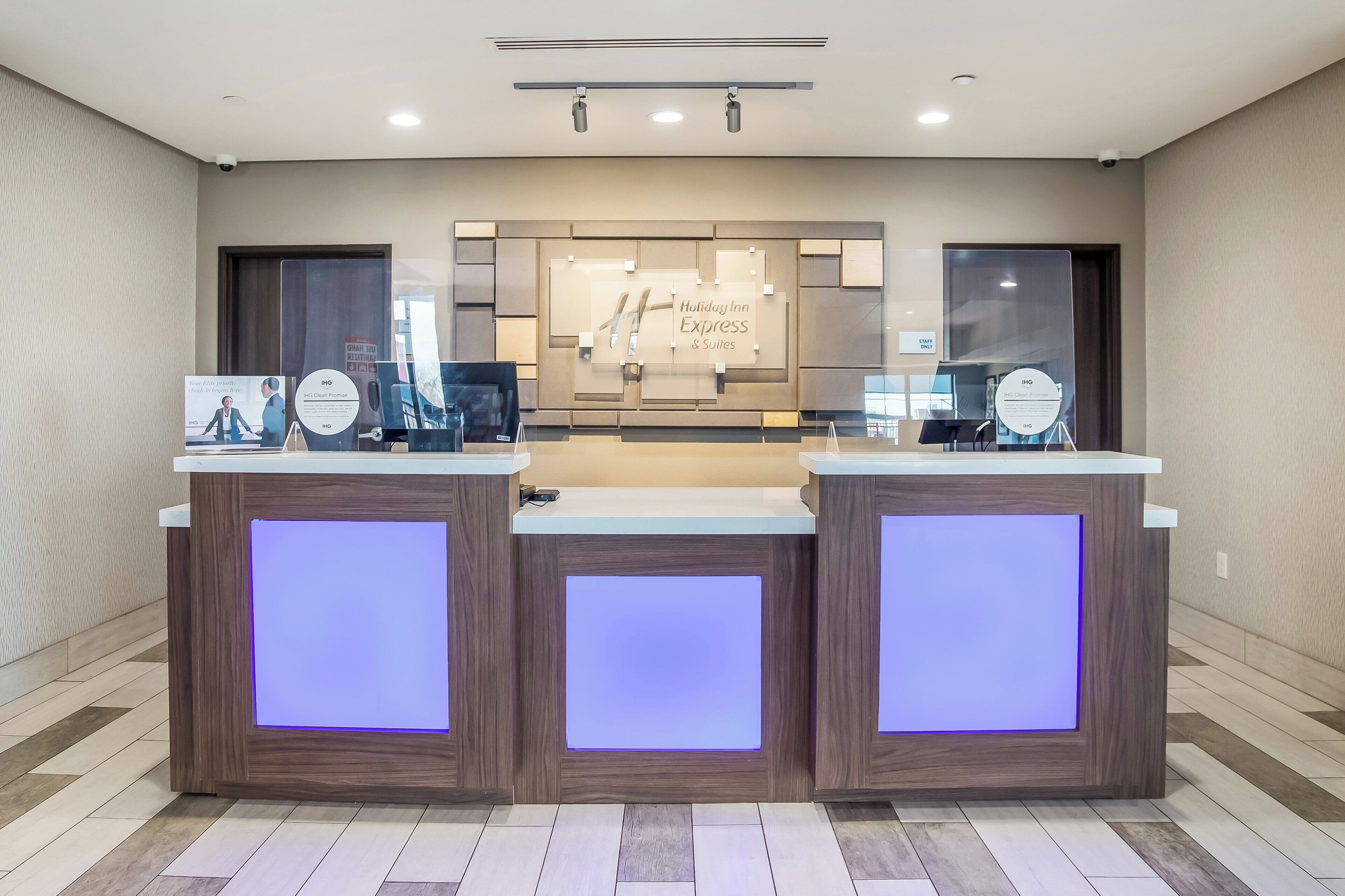 A reception desk with a clean, modern design, featuring a central sign for Holiday Inn Express & Suites.
