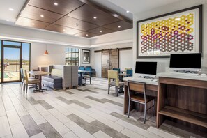 Un intérieur moderne comprenant un coin repas, des sièges et une grande œuvre d’art accrochée au mur.