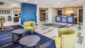 A hotel lobby with a reception desk, seating area, and a children's play area. - Holiday Inn Express & Suites Tulsa East - Catoosa by IHG (Tulsa)