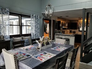 A dining area with a table set for four, featuring a floral centerpiece and festive table mats.