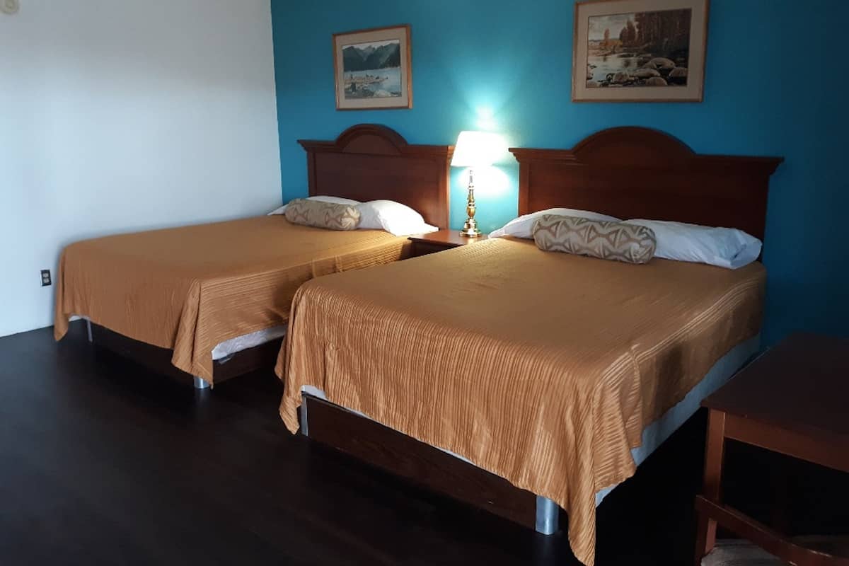 Habitación estándar, 2 camas Queen size, para no fumadores | Tabla de planchar con plancha, wifi gratis y ropa de cama