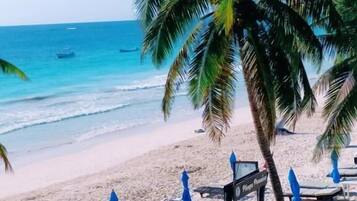 Playa privada, playa de arena blanca, camastros y sombrillas