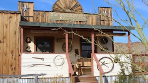 A rustic building with a sign reading "The Sundowner" and a "General Store" sign below.